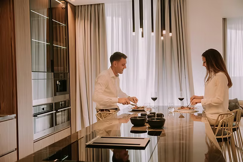 Couple preparing a meal at a kitchen island under pendant lighting