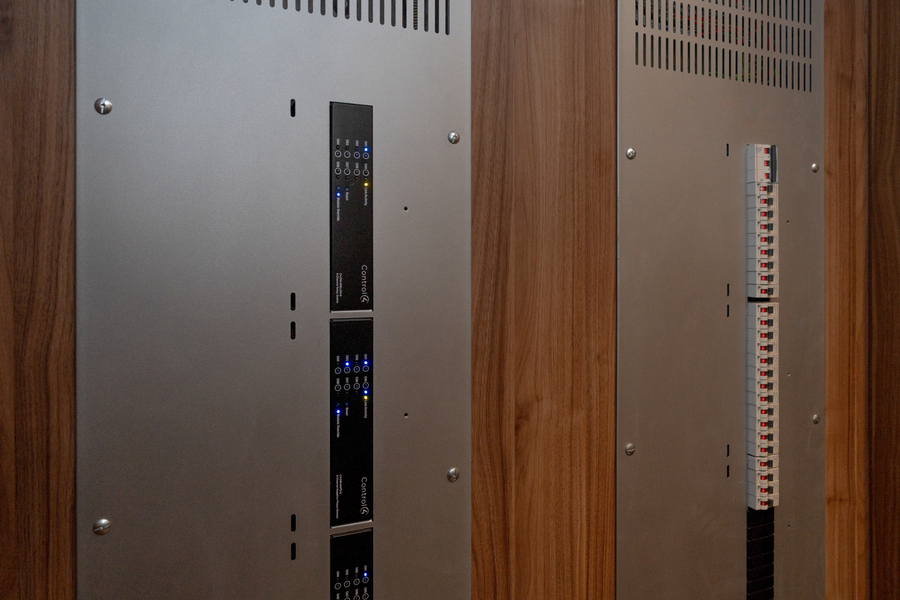 Equipment cabinet with wood and metal panels housing rack-mounted smart home gear