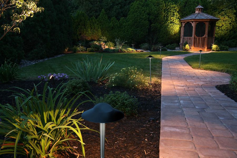 Curved walkway to gazebo illuminated by mushroom-style garden lights