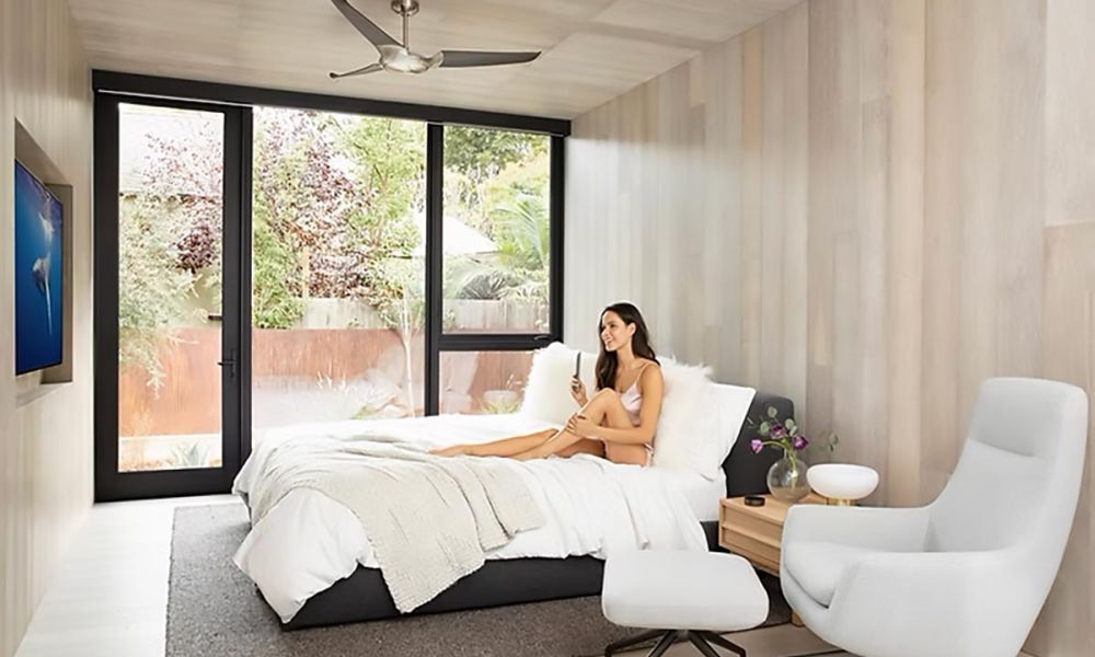 <span class="uk-h4">Woman relaxing on bed in a bedroom with large window</span>