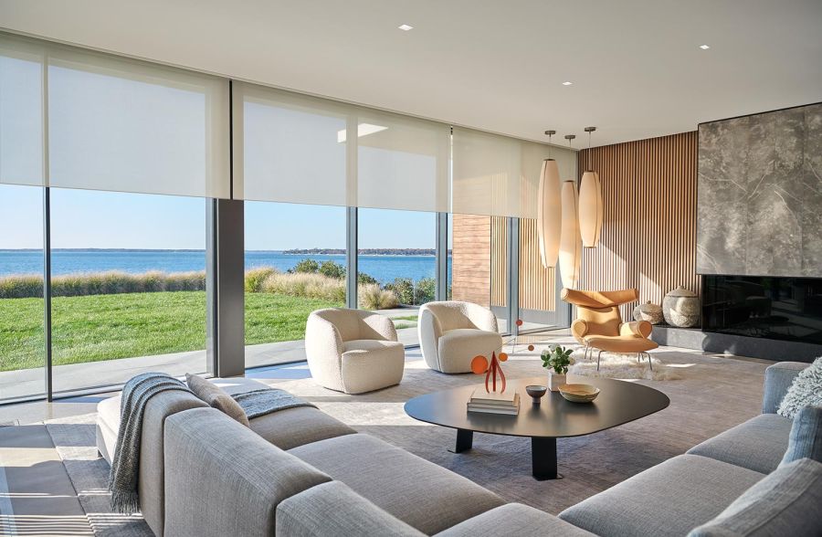Bright living room with motorized shades open to a waterfront view