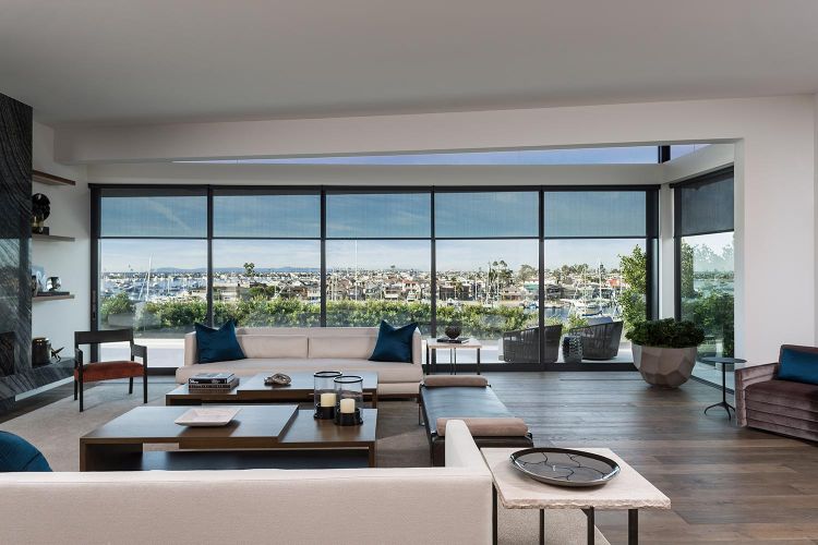 Spacious living room with black window shades and a marina view through floor-to-ceiling windows